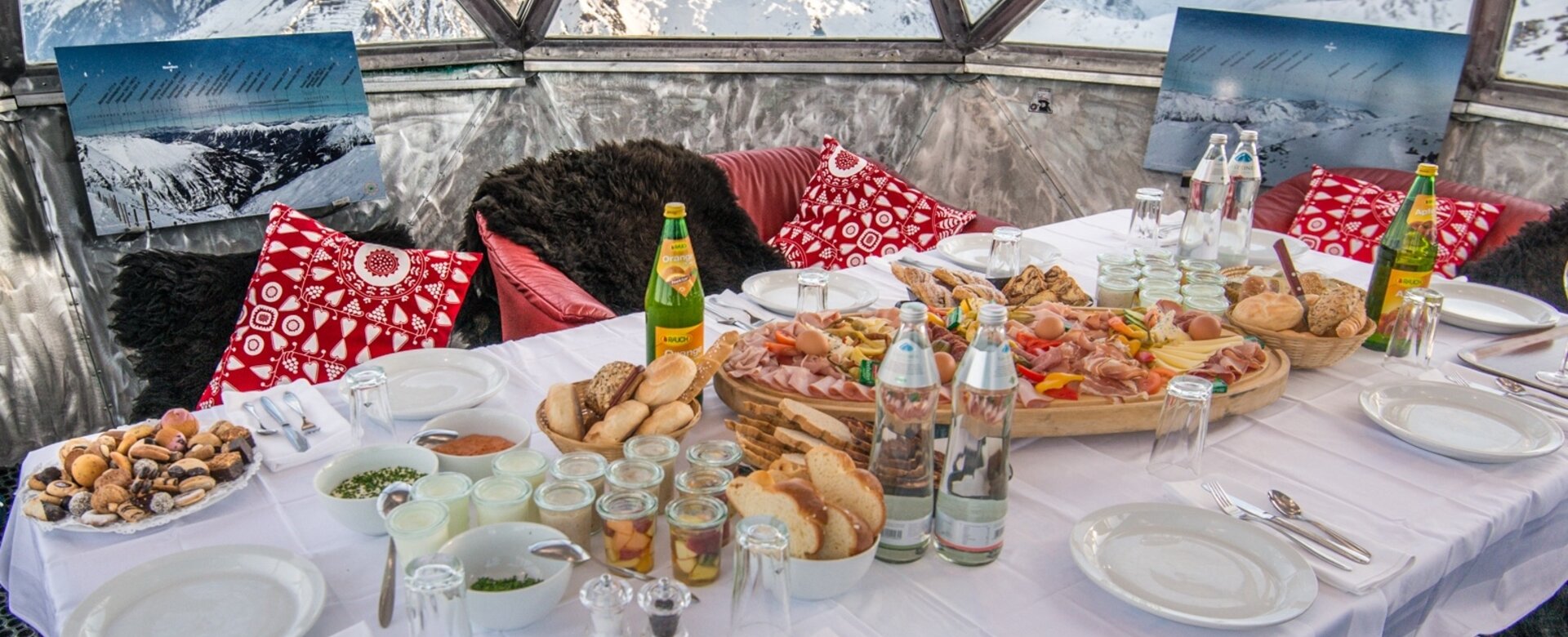 Voll gedeckter Frühstückstisch in einer Aluminiumkupel und mit Aussicht auf die schneebedeckten Berge | © Gasteinertal Tourismus GmbH, Marktl