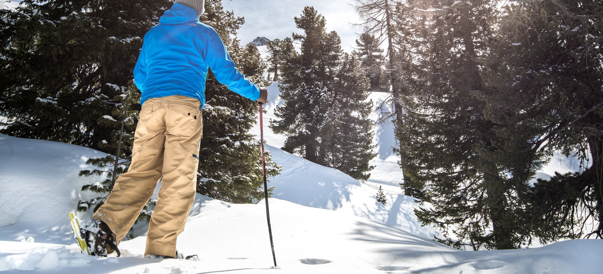 Schneeschuhwanderer geht durch einen tief verschneiten lichten Wald | © Gasteinertal Tourismus GmbH
