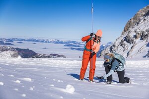 Zwei Frauen üben mit Sonde und LVS-Gerät die Verschüttetensuche im Schnee am Gletscher. | © René Eduard Perhab