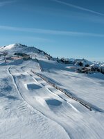 Drohnenaufnahme einer Pistenlandschaft mit Schneeschanzen