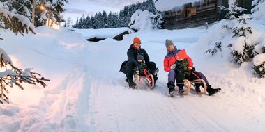 Parents and kids tobogganing together on winter holiday in Gastein | © GTG