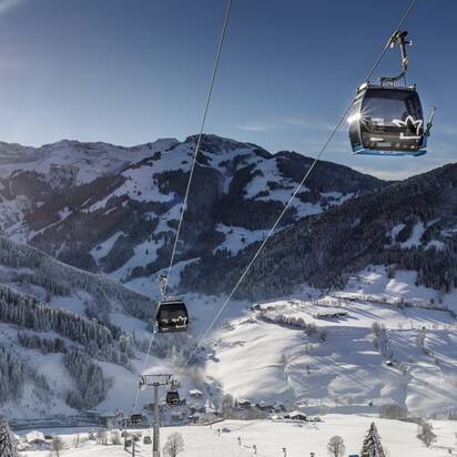 Sonnbergbahn gondolas move above snowy slopes near Maria Alm in winter sunshine | © www.felsch-foto.at