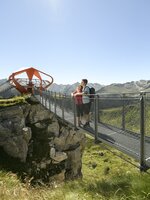 Two people enjoy the view on Stubnerkogel’s cliff trail toward Glocknerblick platform in bright sunny weather | © Gasteiner Bergbahnen, Marktl Photography