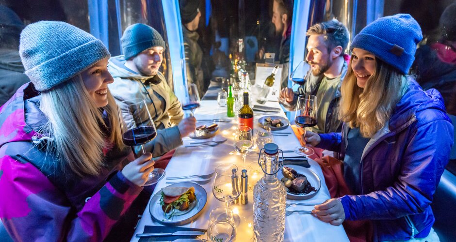 Two couples sit in a beautifully set gondola with wine, main course and laugh at each other. | © Edith Danzer 
