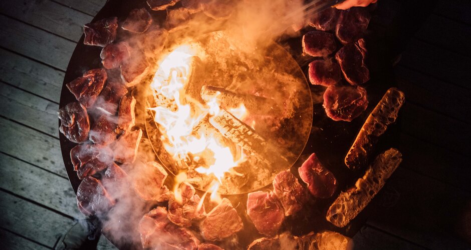 Feuerkessel von oben und am Kesselrand wird Fleisch gebraten | © Chris Perkles