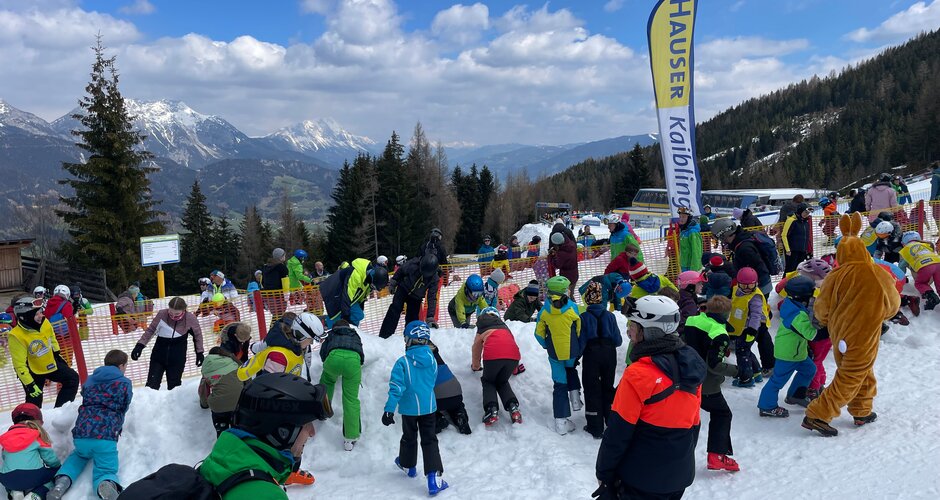 Kids search for Easter eggs in the snow at Hauser Kaibling with snowy mountains in the background | © Hauser Kaibling