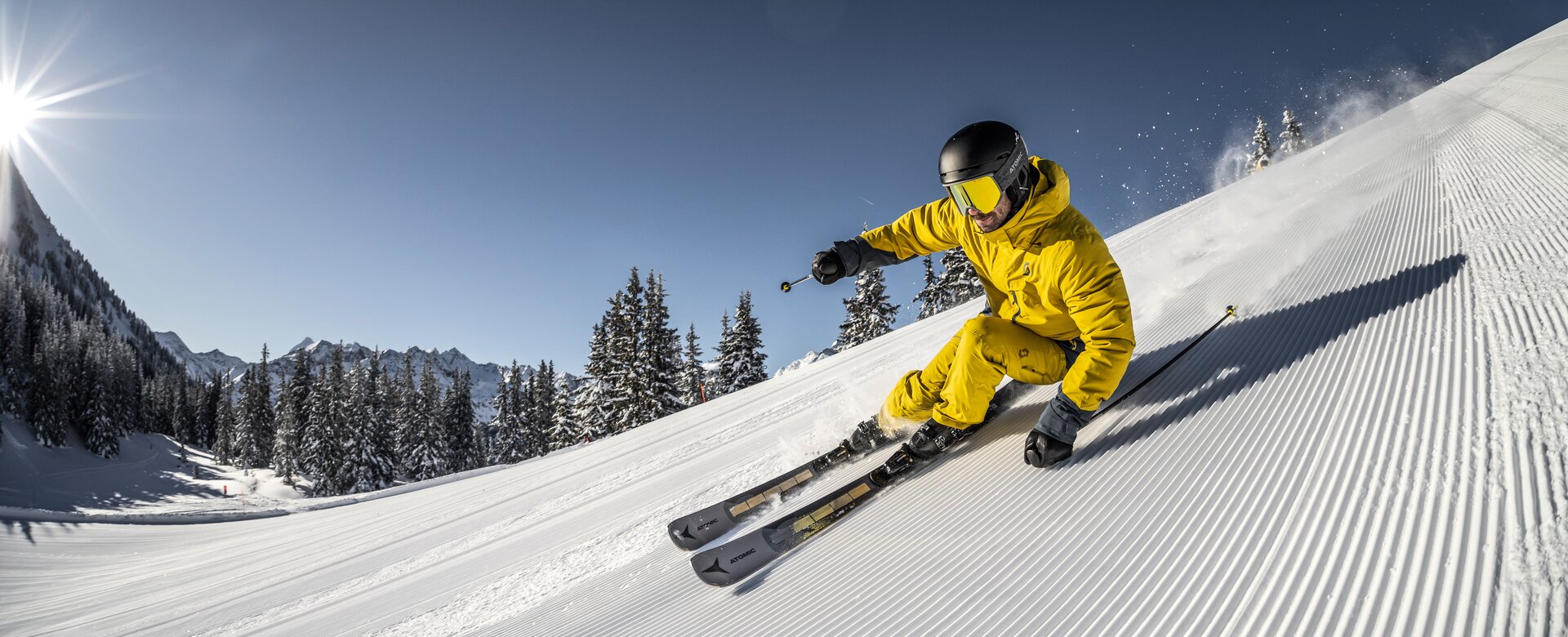 Skifahrer in gelben Skianzug fährt die frisch präparierte Piste hinunter | © Mirja_Geh