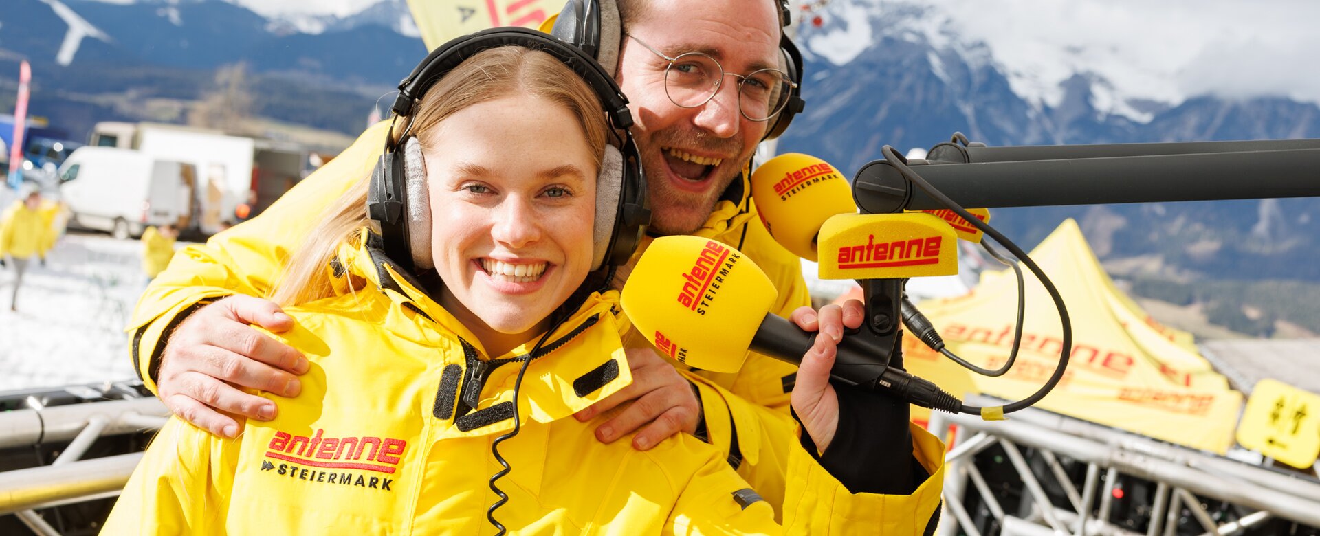 Two cheerful radio hosts with headsets broadcasting live from Antenne Snowday on Planai. | © Erwin Scheriau