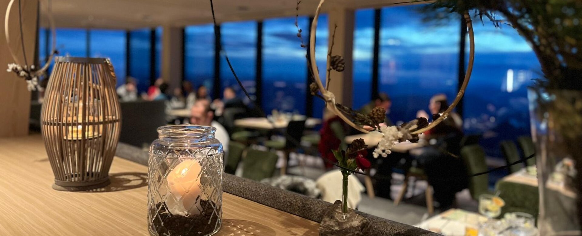 Candle decoration in glass jar with evening view of Dachstein during festive Advent atmosphere | © Planai-Hochwurzen-Bahnen