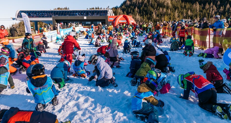 Zahlreiche Kinder suchen auf Knien im Schnee nach Schätzen bei einer Aktion an der Reiteralm | © Gerald Grünwald