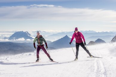 Zwei Langläuferinnen in Winterlandschaft am Dachstein, Schnee und Berge im Hintergrund. | © Harald Steiner