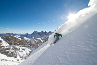 Skifahrer fährt steile Pulverschnee-Abfahrt im Edelgrießgebiet am Dachstein, blauer Himmel. | © Andy Kocher