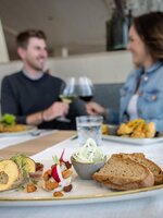 Paar genießt regionale Speisen im Gletscherrestaurant Dachstein mit Wein und Brot. | © Harald Steiner