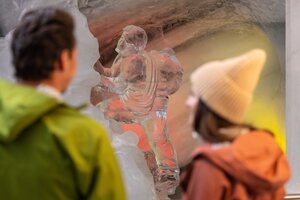 Two people looking at an ice sculpture of a climber in the Dachstein Ice Palace. | © Harald Steiner