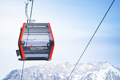 Rote Gondelbahn von Galsterberg vor schneebedeckten Bergen. | © Josh Absenger