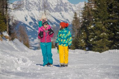 Zwei Frauen mit Kind wandern im Schnee, Berge im Hintergrund. | © Christine Höflehner