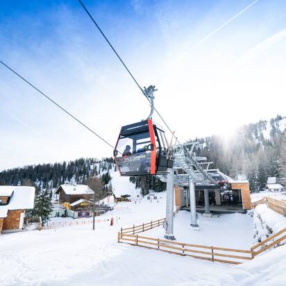 Red Galsterberg gondola above top station with snowy landscape. | © Josh Absenger