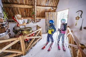 Two kids in ski clothes look at a magic potion station at Galstiland, Galsterberg. | © Mirja Geh
