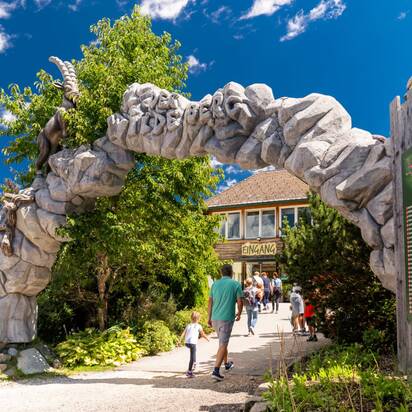 Visitors walk through the stone entrance gate to Wilde Berg in Mautern with animal figures. | © Christine Höflehner