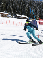 Skier in a blue suit navigates a slalom course on Planai, closely passing a gate. | © Herbert Raffalt