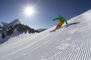 Skier in green helmet carving on a freshly groomed slope at Planai. | © Gregor Hartl
