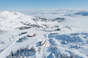 Snowy Shuttleberg ski area with lifts, huts and mountain scenery in clear and sunny weather | © Shuttleberg