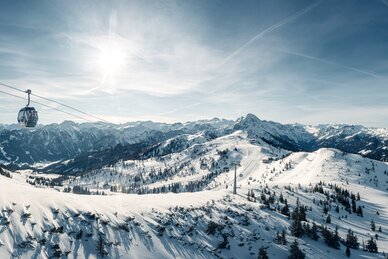 Picture of the cable car on the shuttle mountain as it crosses over the piste and the snowy slopes | © Markus Rohrbacher