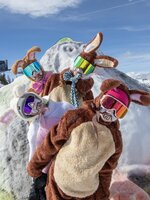 Four people in colorful bunny costumes and ski goggles posing playfully on a snowy hilltop | © Shuttleberg