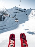 St. Johann – Alpendorf ski area with chairlift, snowy slopes, skiers and mountains
