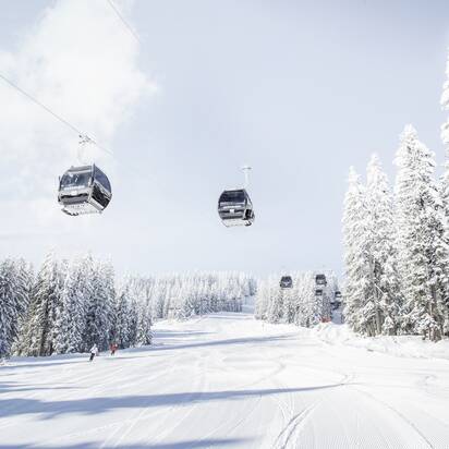 Achterjet gondola Flachau with cabins, snowy fir trees and groomed slope | © Snow Space Salzburg