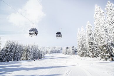 Achterjet gondola Flachau with cabins, snowy fir trees and groomed slope | © Snow Space Salzburg