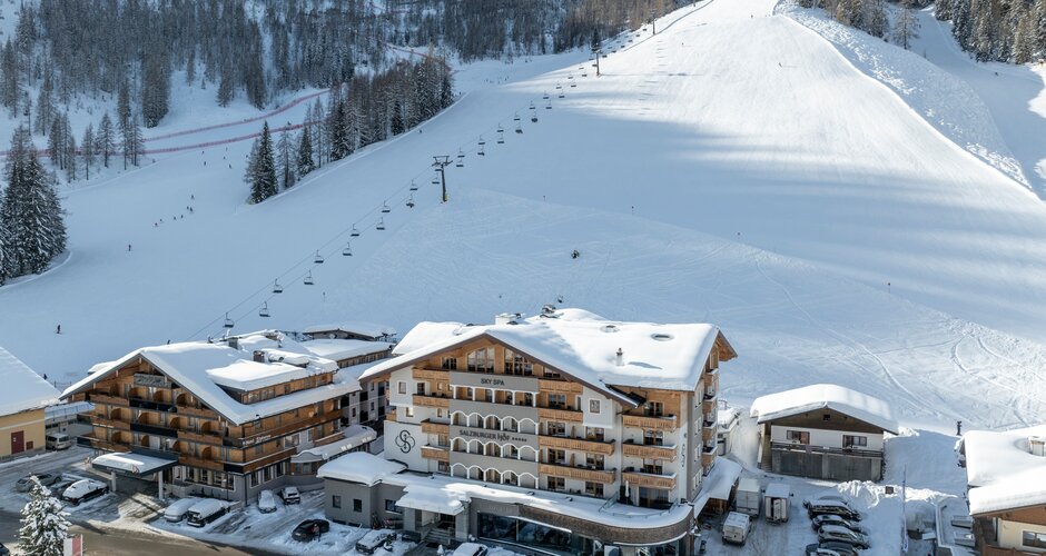 Hotel Salzburger Hof with parking in front of wide ski slope and chairlift | © Lorenz Masser