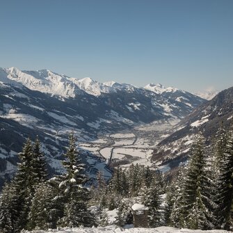 View of a snow-covered valley surrounded by mountains to the left and right | © Georg Roske