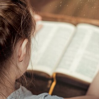 Kind beim Lesen in der Bibel