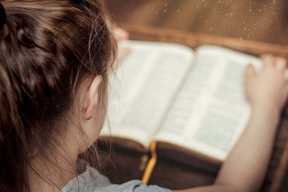 Kind beim Lesen in der Bibel