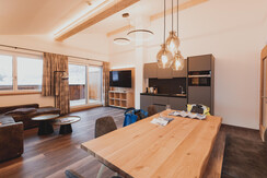 Wohnraum mit Küche und großem Esstisch