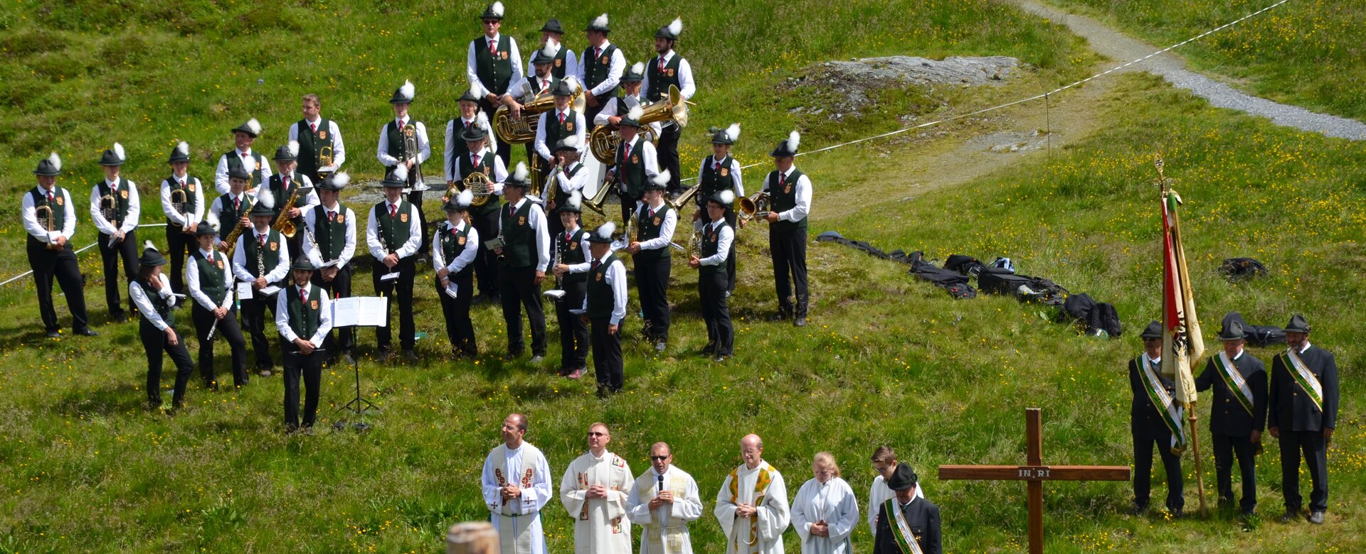 Priests next to a cross and a band in the background