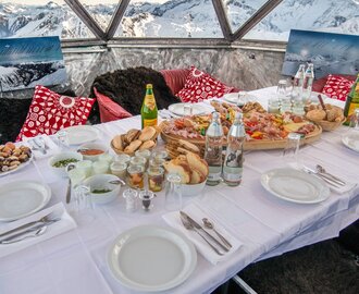 Voll gedeckter Frühstückstisch in einer Aluminiumkupel und mit Aussicht auf die schneebedeckten Berge | © Gasteinertal Tourismus GmbH, Marktl