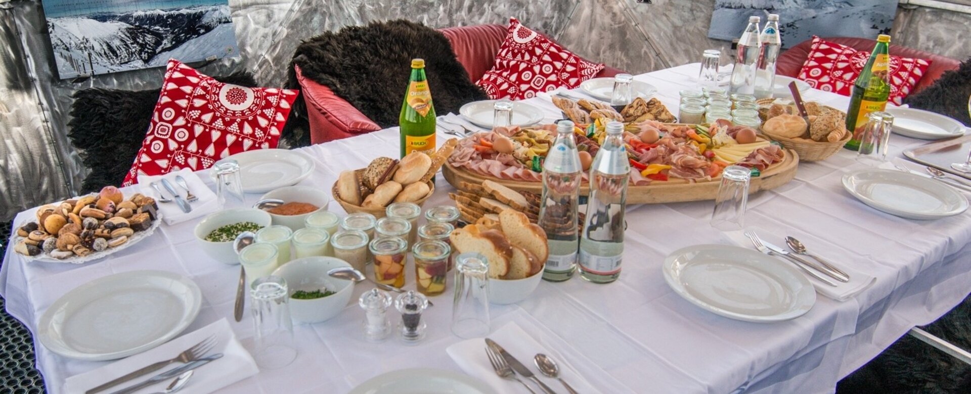 Fully laid breakfast table in an aluminium cupola with a view of the snow-capped mountains | © Gasteinertal Tourismus GmbH, Marktl