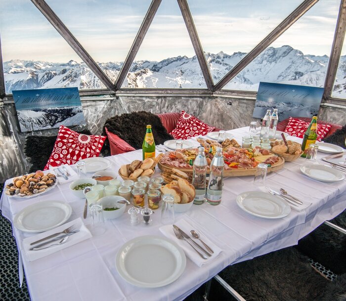 Voll gedeckter Frühstückstisch in einer Aluminiumkupel und mit Aussicht auf die schneebedeckten Berge | © Gasteinertal Tourismus GmbH, Marktl