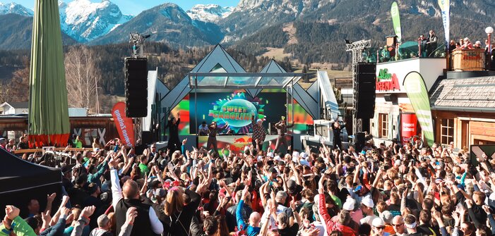 Singer DJ Ötzi stands on stage and sings while the crowd in front of the stage sings along with raised arms. | © Hauser Kaibling