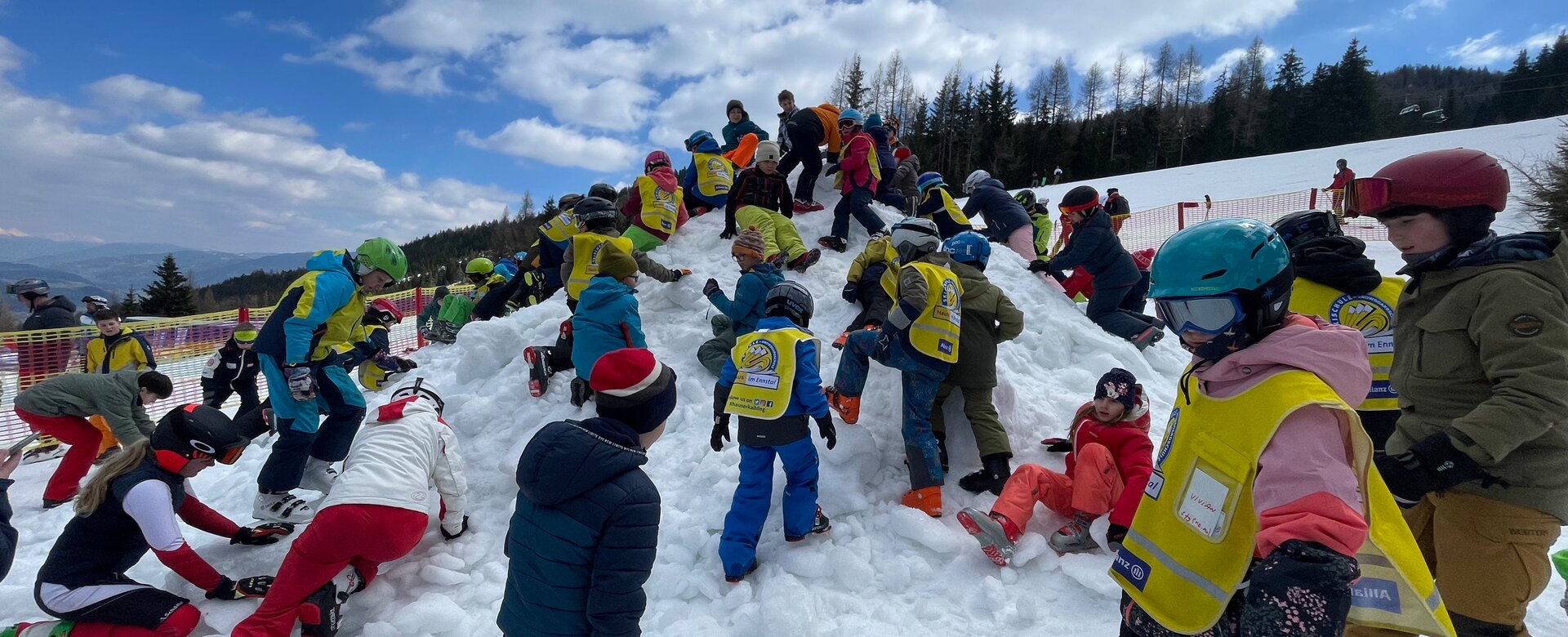 Viele Kinder in Skianzug butteln auf einem Hügel nach Ostereiern. | © Hauser Kaibling
