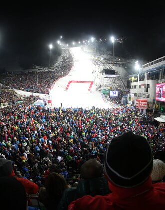 Crowd stands around the finish line of the men's slalom