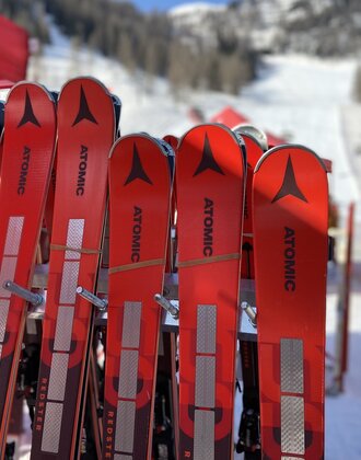 Rote Atomic Skipaare lehnen an einem Skiständer