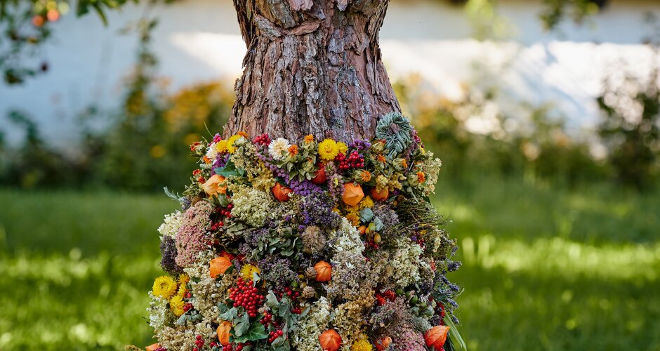 Mannequin dressed in an autumn gown made of tree bark, dried flowers and berries – part of the Herbst.Königin event | © Matthias Fritzenwallner
