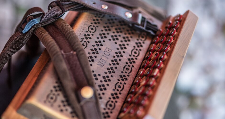 Close-up of a Styrian harmonica with decorated leather, buttons and straps at the Musikanten.Roas folk event | © Nadia Jabli Photography