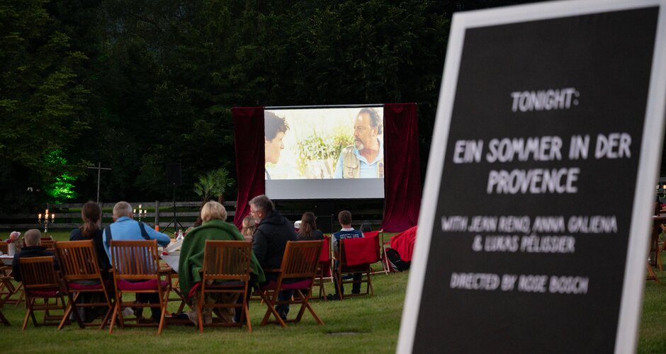 Audience seated outdoors at the Licht.Spiele open-air cinema watching “A Summer in Provence” on the big screen | © Matthias Fritzenwallner