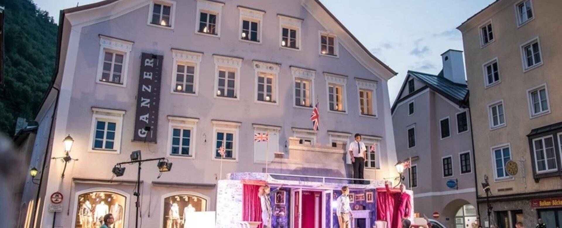 Straßentheater mit Bühne und Publikum vor altem Haus in Altstadt bei Dämmerung