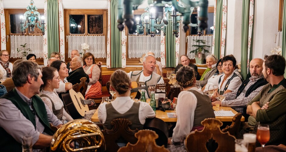 People in traditional attire making music at cosy Herbstg'sang evening in Flachau | © Flachau Tourismus