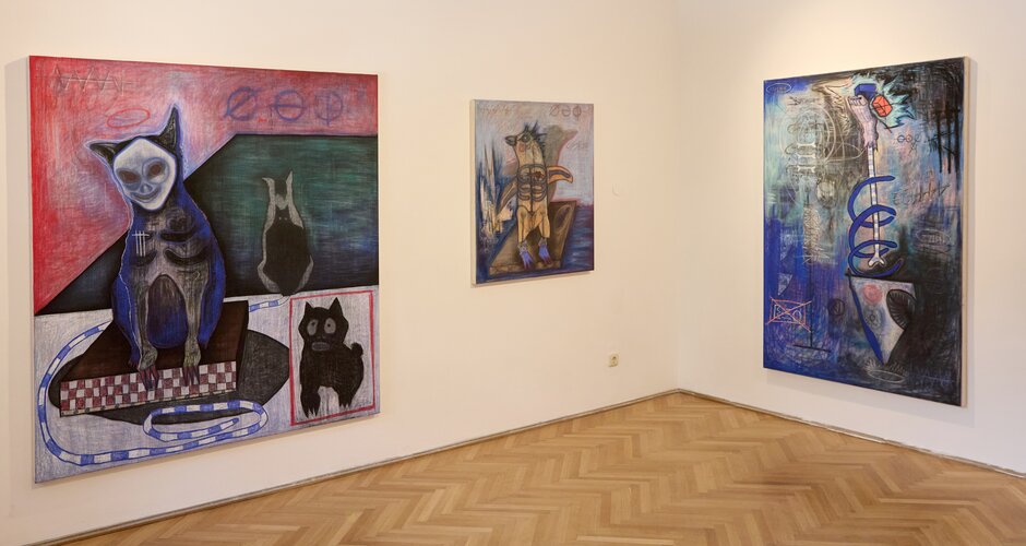 Three expressive paintings by Pascal Koertel displayed in a gallery room with wooden floor and white walls | © Florian Kolmer